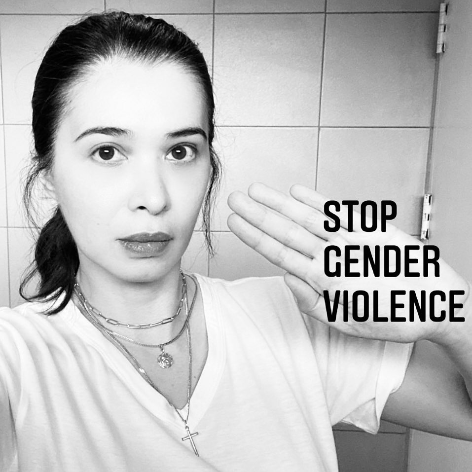 Sunshine Cruz holding her hand up with the words STOP GENDER VIOLENCE