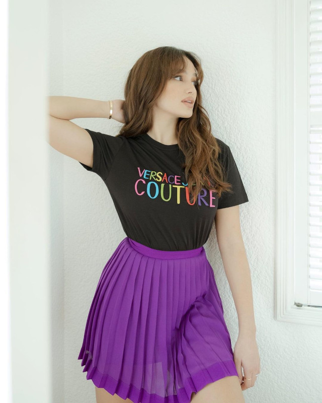Home Photo Shoot Idea: Sarah Lahbati wearing black shirt and a purple skirt.