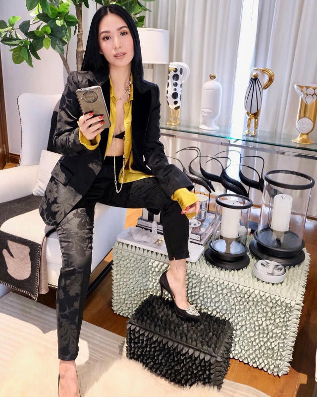 Heart Evangelista wearing two button down tops, bikini top, and black trousers.