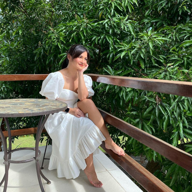 Camille Prats wearing a white dress with puff sleeves