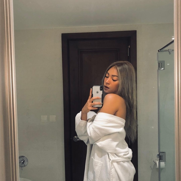 Christine Samson draping her white robe in a mirror selfie