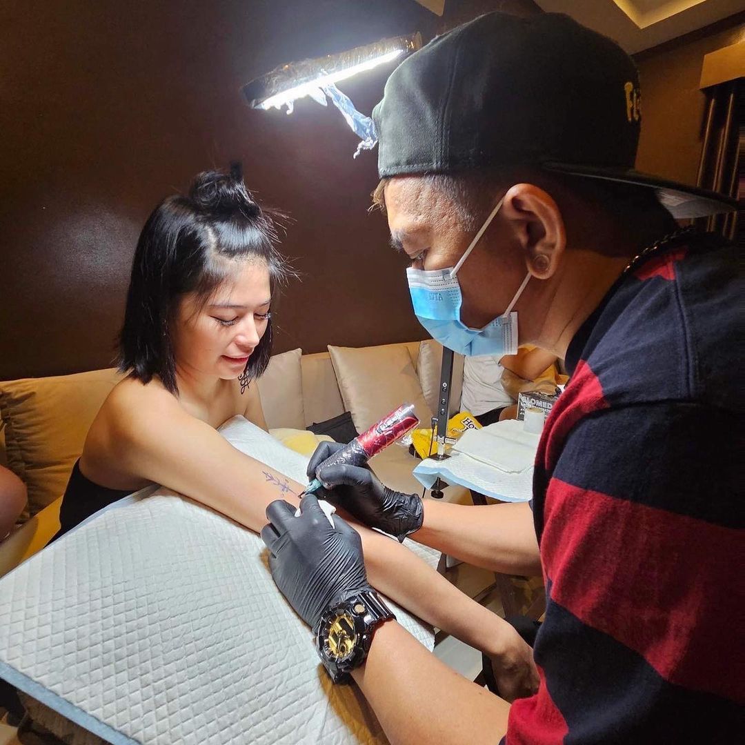 Gigi de Lana getting tattooed
