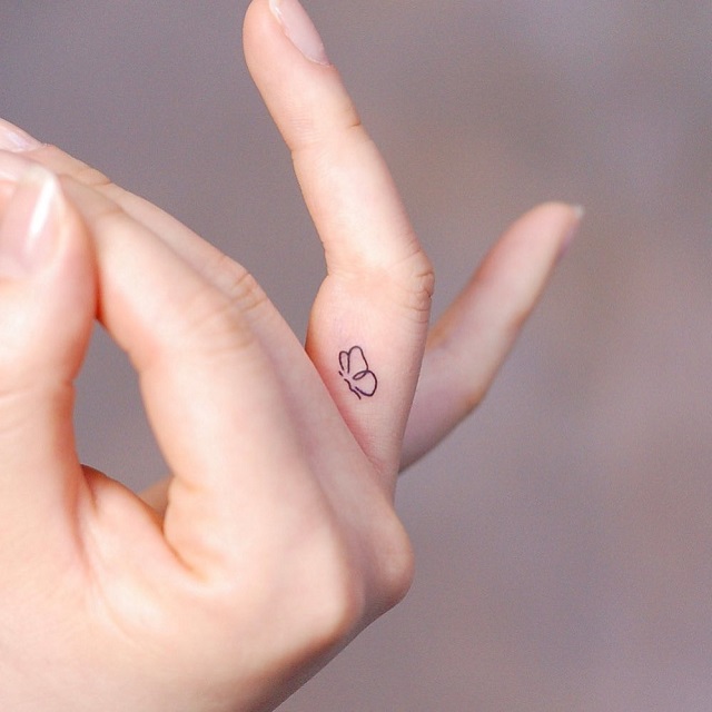 Minimalist daisy flower tattoo on the finger