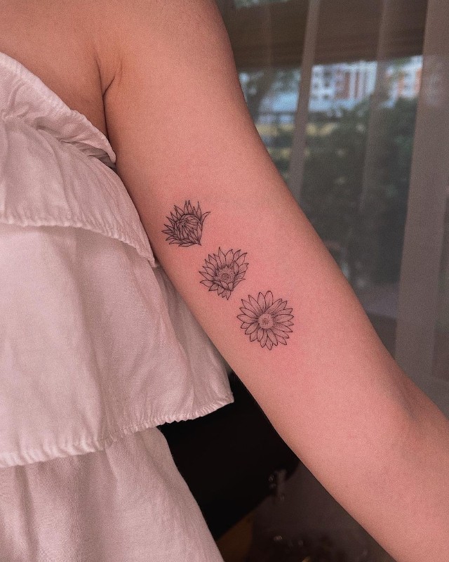 Minimalist sun and sunflower tattoo on the wrist