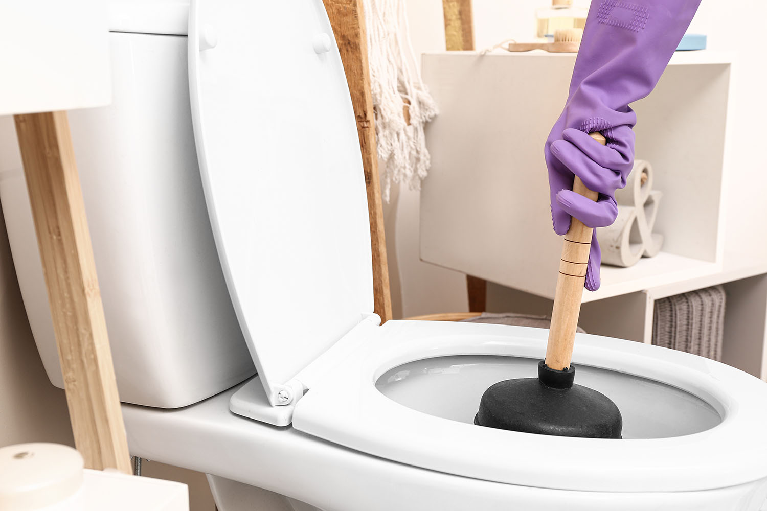 unclogging a toilet with plunger
