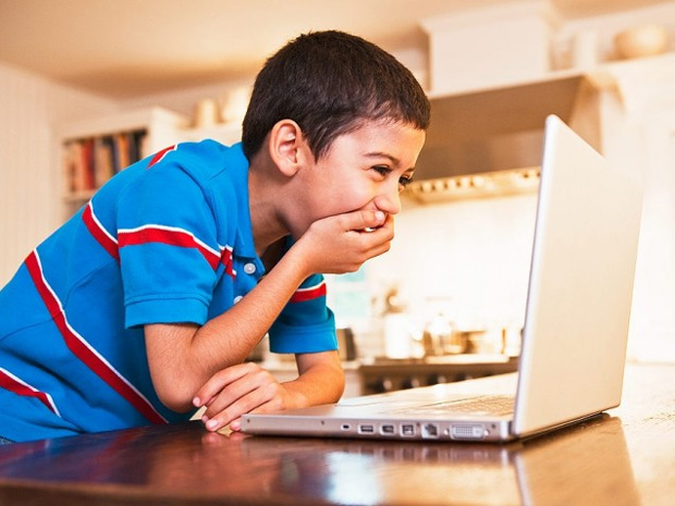 child laughing while watching on computer
