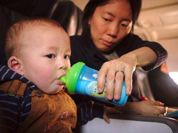 adult feeding a child on an airplane
