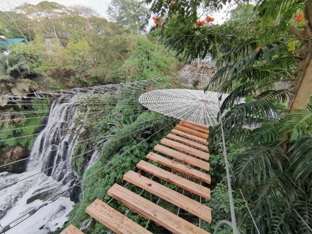A spider web hangs above the 21-meter waterfalls