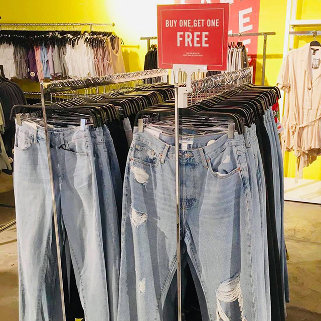 Tattered jeans on display at Forever 21 with a Buy 1 Get 1 Free tag.