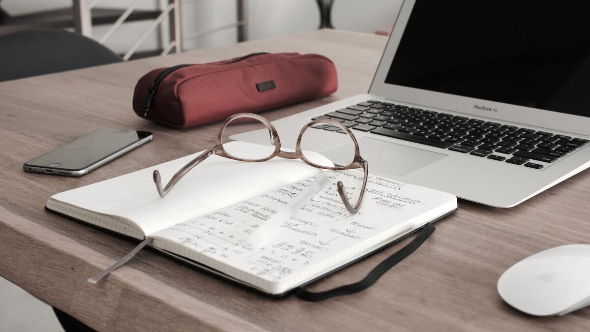 notebook with glasses and open laptop