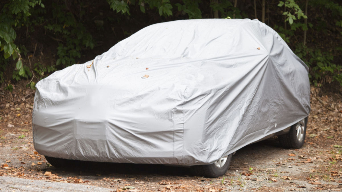 A parked car with a car cover