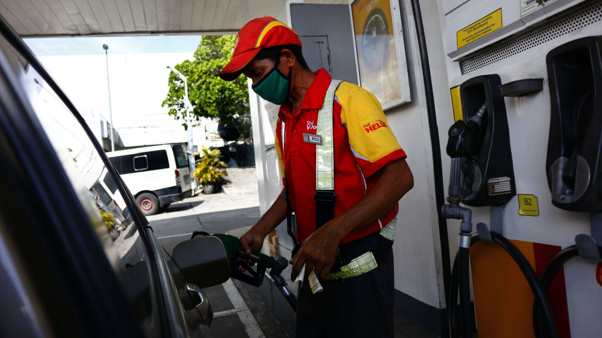 A fuel station attendant refueling a vehicle