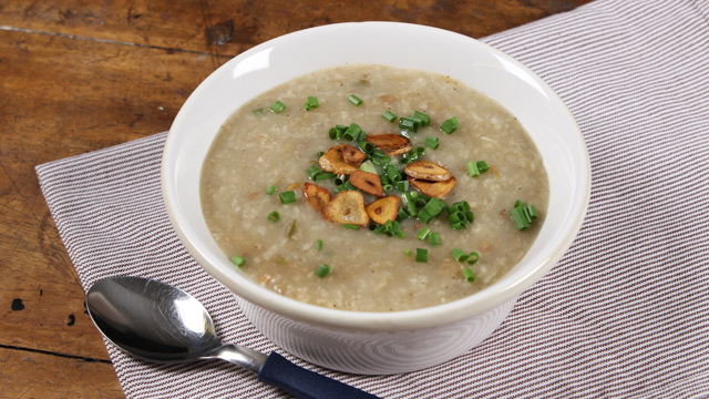 arroz caldo topped with toasted garlic and chopped green onions