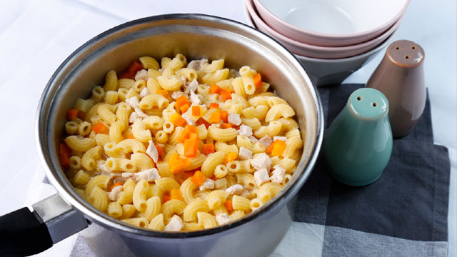 sopas with macaroni, carrots, and chicken in a stainless steel pot