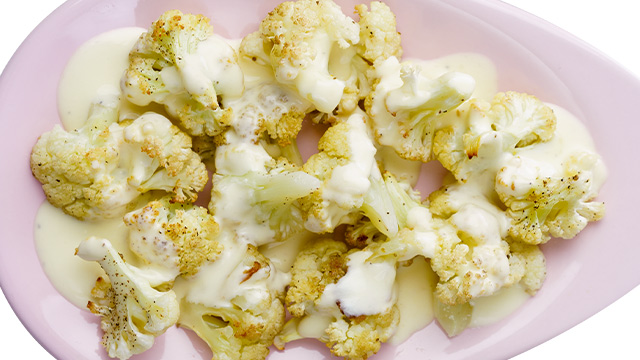 This head of cauliflower is simply roasted in the oven and drizzled with creamy cheese sauce.