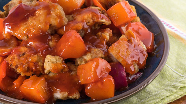 sweet and sour chicken on a black plate
