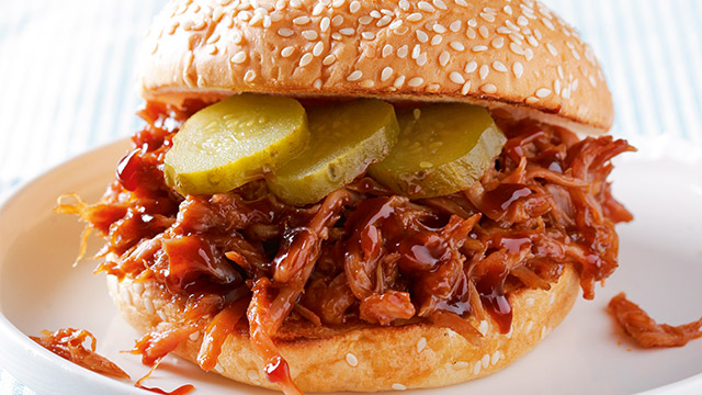 Pulled chicken sandwich with barbecue sauce and pickles