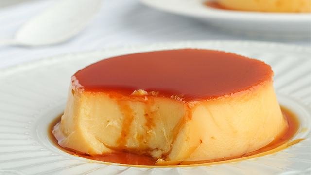 round leche flan on a white plate