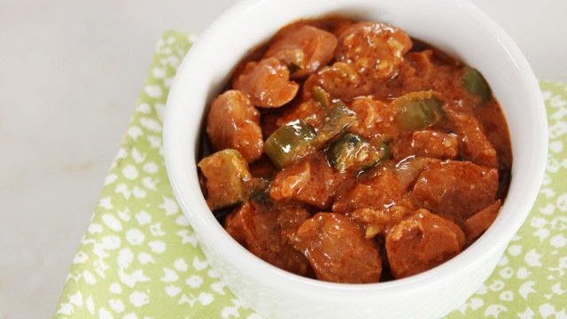Marikina menudo with sliced sweet pickles in a white bowl