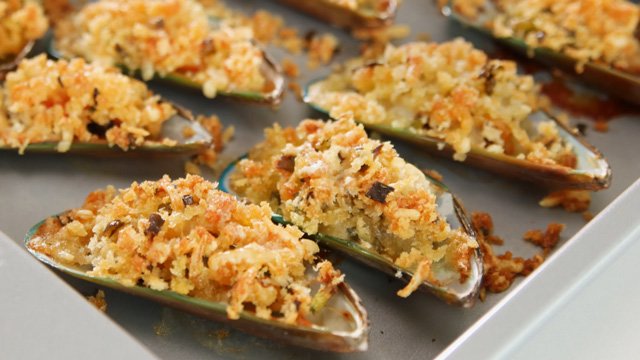 baked tahong or mussels topped with crunchy garlic and breadcrumbs on an aluminum tray
