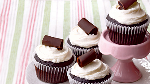 Caramel-filled chocolate cupcakes with whipped cream and chocolate shaving