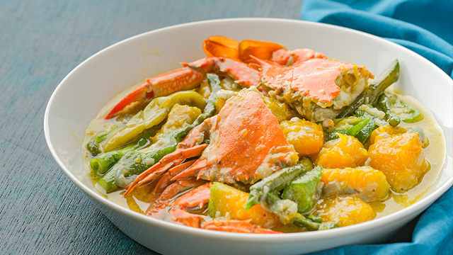 ginataang alimasag or crabs in coconut milk stew with squash and string beans in a white bowl.
