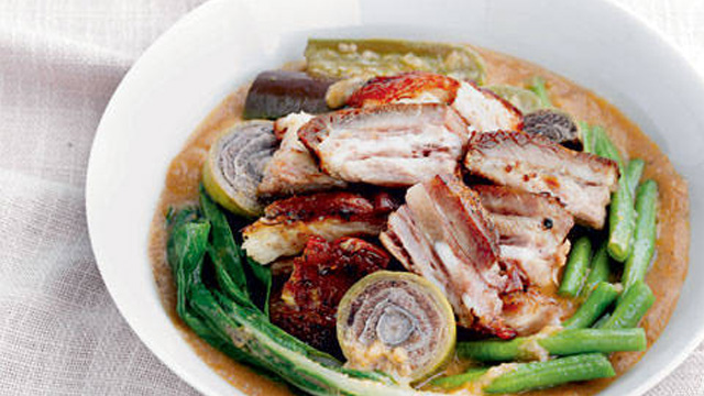 kare-kare topped with slices of lechon kawali