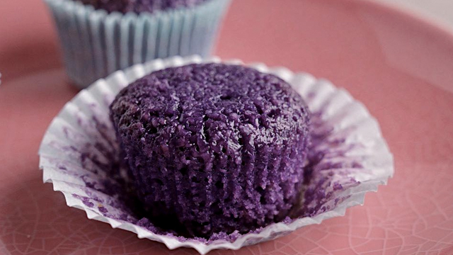 Moist, chewy, soft ube macaroon resting on a cupcake liner.
