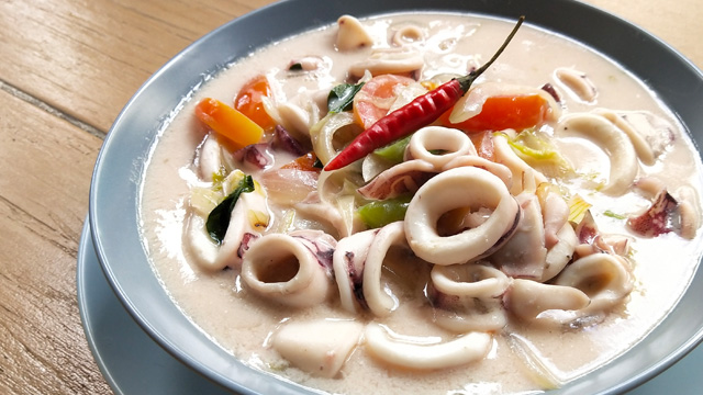 ginataang pusit or squid in coconut milk in a blue bowl